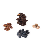 Cluster of blueberry, cluster of pecans, cluster of nutmeg, and cluster of chocolate superfood snack